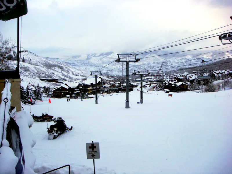 Snowy Snowmass Village, gondola infrastructure and resort buildings.